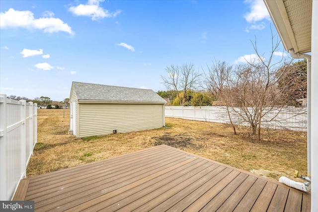 wooden terrace featuring a yard, an outdoor structure, and a fenced backyard