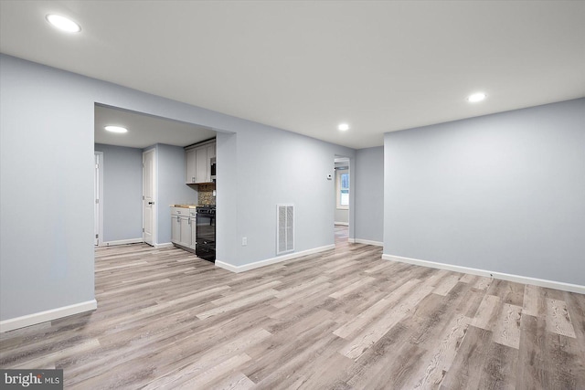 interior space featuring light wood-style flooring, visible vents, baseboards, and recessed lighting