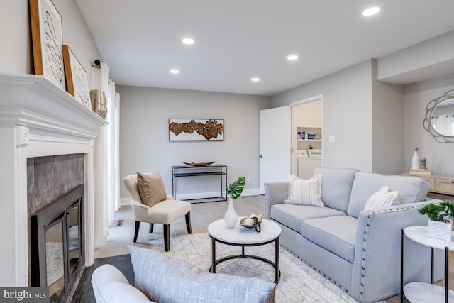 living area with baseboards, a fireplace, washing machine and dryer, and recessed lighting