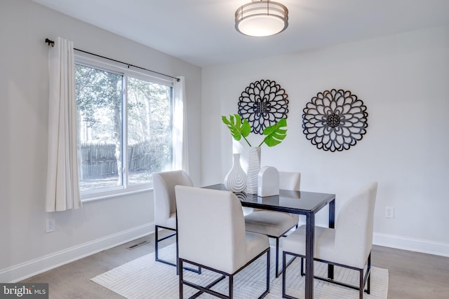 dining room featuring visible vents, baseboards, and wood finished floors