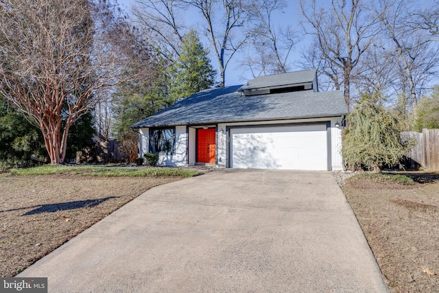 view of front facade with a garage, driveway, roof with shingles, and fence