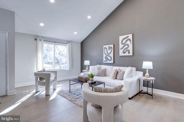 living room featuring light wood-style floors, baseboards, high vaulted ceiling, and recessed lighting