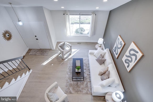 living area with recessed lighting, stairway, baseboards, and wood finished floors