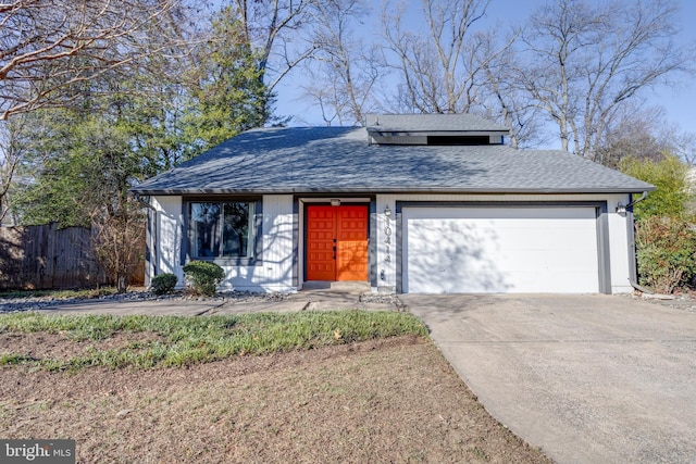 view of front facade featuring a garage, a shingled roof, fence, and concrete driveway