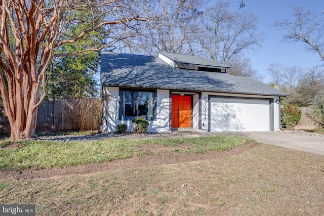 mid-century inspired home featuring driveway, a shingled roof, an attached garage, and fence