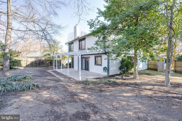 back of property with a patio, a chimney, and a fenced backyard