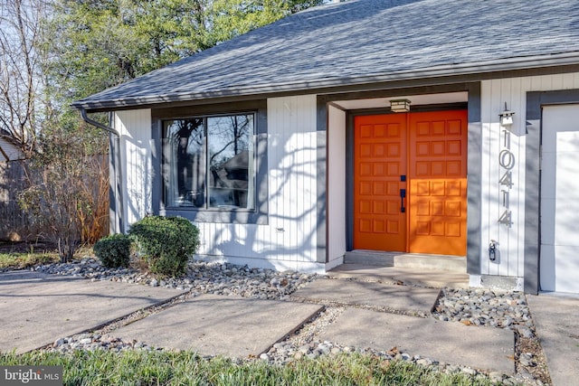 view of exterior entry with a shingled roof