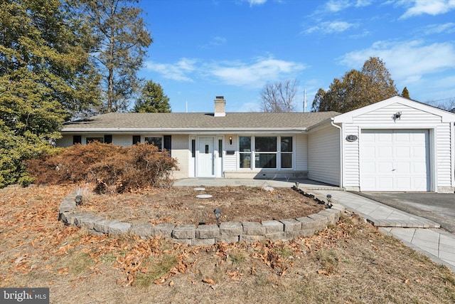 single story home with brick siding, a chimney, a shingled roof, a garage, and driveway