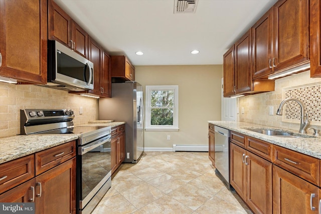 kitchen featuring stainless steel appliances, baseboard heating, a sink, light stone countertops, and baseboards