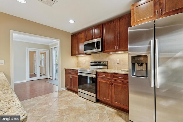 kitchen with light stone counters, light tile patterned floors, visible vents, decorative backsplash, and appliances with stainless steel finishes