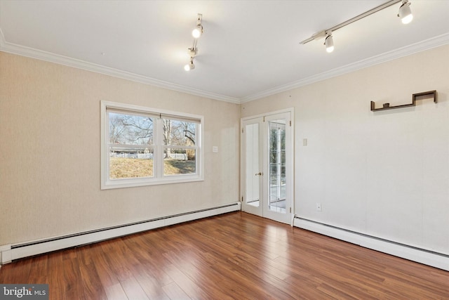 unfurnished room featuring a baseboard heating unit, wood finished floors, and ornamental molding