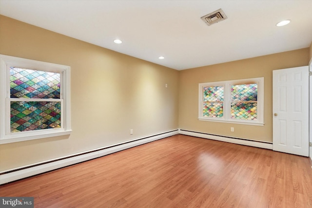 unfurnished room with recessed lighting, visible vents, light wood finished floors, and a baseboard radiator