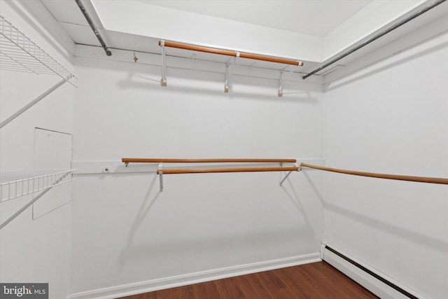 walk in closet with baseboard heating and dark wood-style flooring