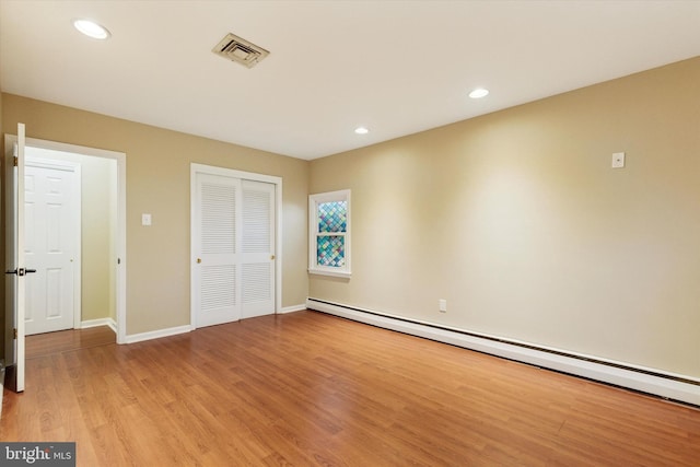 unfurnished bedroom featuring recessed lighting, visible vents, baseboard heating, light wood-type flooring, and a closet