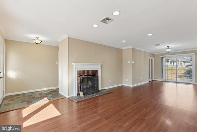 unfurnished living room with a fireplace with raised hearth, wood finished floors, visible vents, baseboards, and ornamental molding