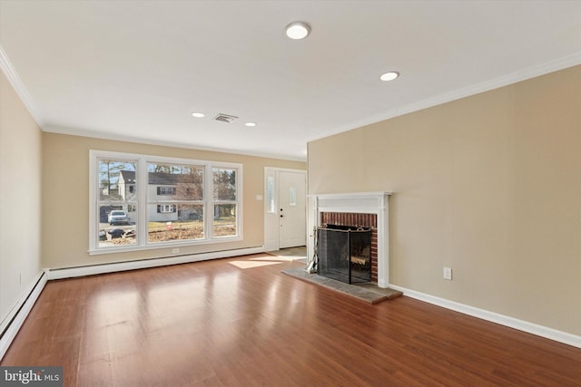 unfurnished living room with visible vents, a baseboard radiator, ornamental molding, wood finished floors, and a fireplace