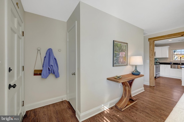 hall with baseboards and wood finished floors