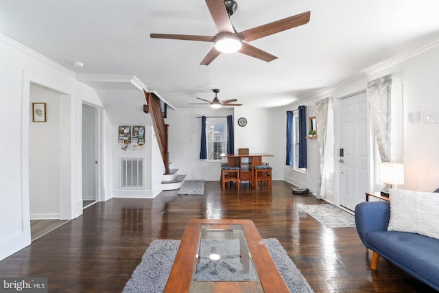 living area with baseboards, visible vents, ornamental molding, wood finished floors, and stairs