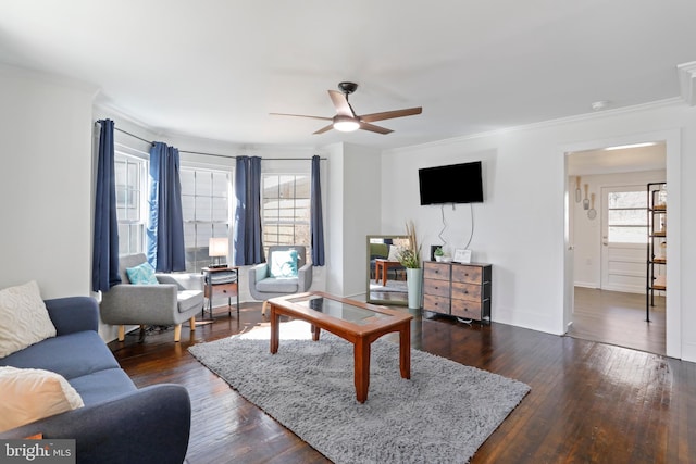 living area featuring baseboards, ornamental molding, dark wood finished floors, and a ceiling fan