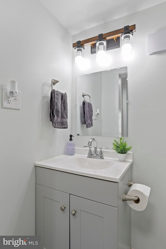 bathroom with an AC wall unit and vanity