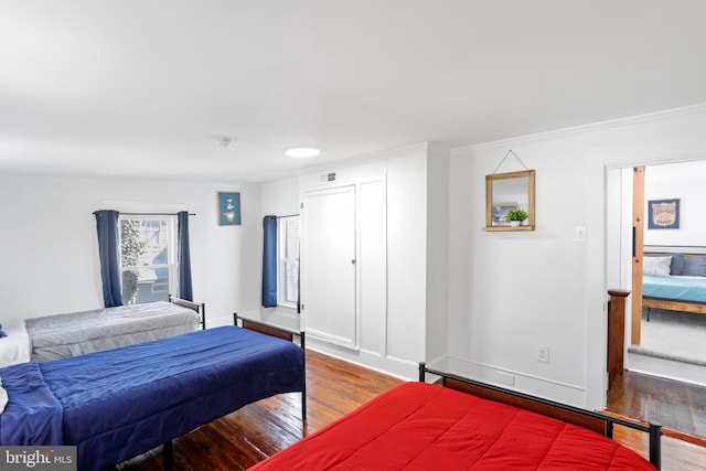 bedroom featuring wood finished floors, visible vents, and baseboards