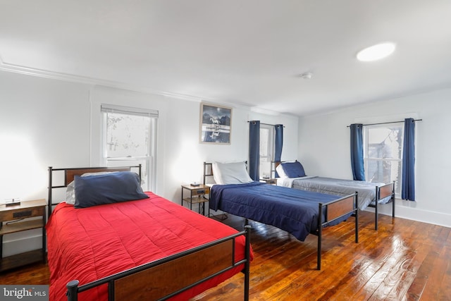 bedroom with crown molding, baseboards, and hardwood / wood-style flooring