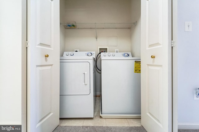 clothes washing area featuring washer and dryer, laundry area, and light tile patterned floors