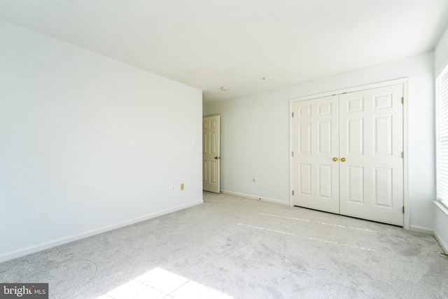 unfurnished bedroom featuring a closet, baseboards, and carpet flooring