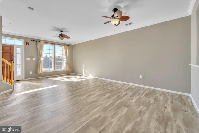 unfurnished living room with visible vents, ornamental molding, light wood-style flooring, and baseboards