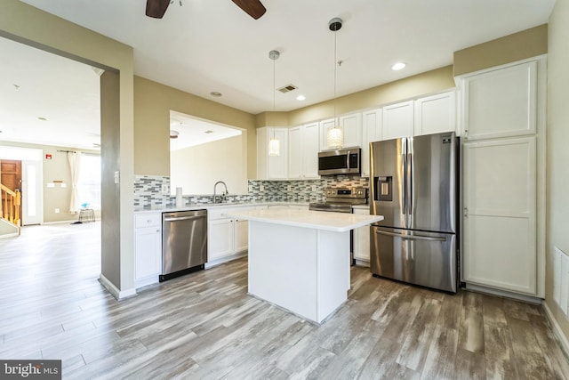 kitchen featuring tasteful backsplash, visible vents, white cabinets, stainless steel appliances, and light countertops