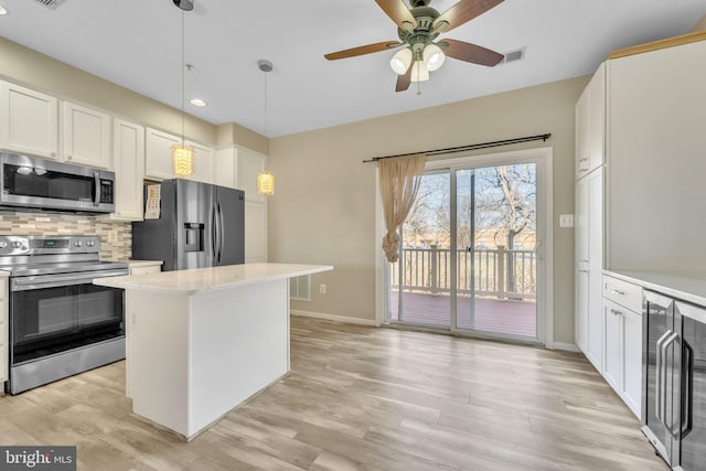 kitchen with stainless steel appliances, visible vents, light wood-style floors, light countertops, and decorative backsplash