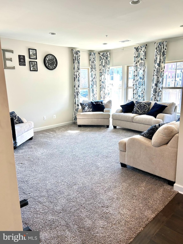 carpeted living area featuring visible vents and baseboards