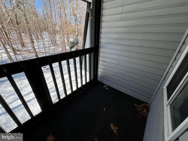 view of snow covered back of property