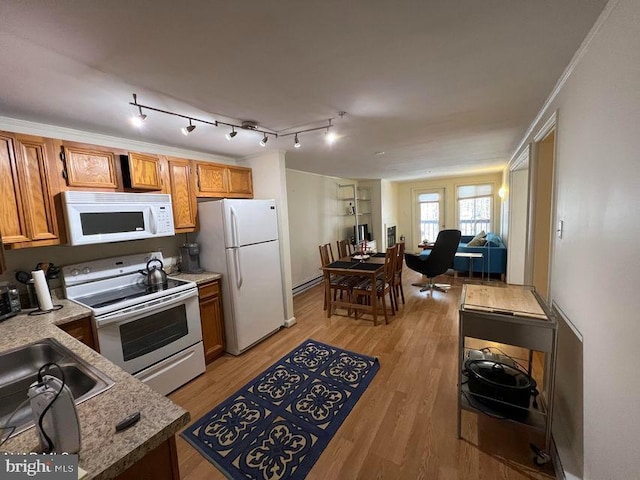 kitchen featuring white appliances, light wood-style flooring, light countertops, and brown cabinetry