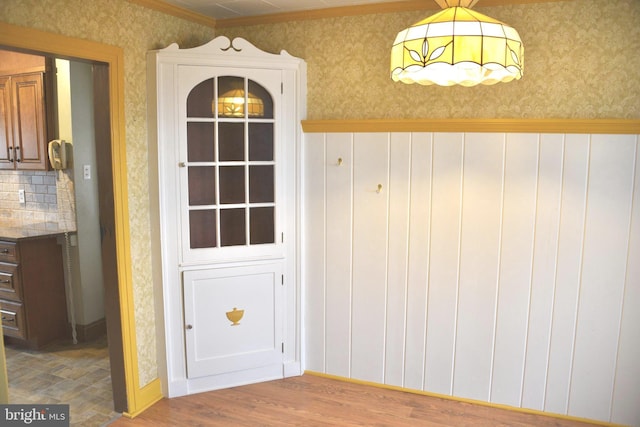 doorway to outside featuring wood finished floors and wallpapered walls