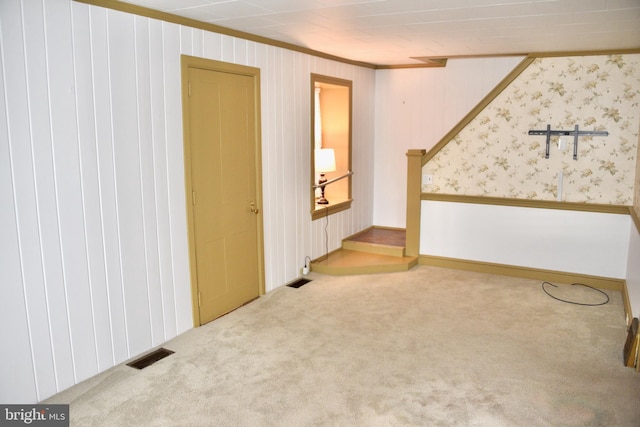 carpeted spare room featuring stairs, visible vents, and ornamental molding