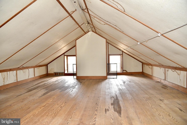 bonus room with plenty of natural light, visible vents, vaulted ceiling, and hardwood / wood-style floors