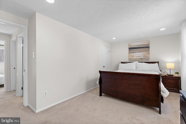 carpeted bedroom featuring recessed lighting, a textured ceiling, and baseboards