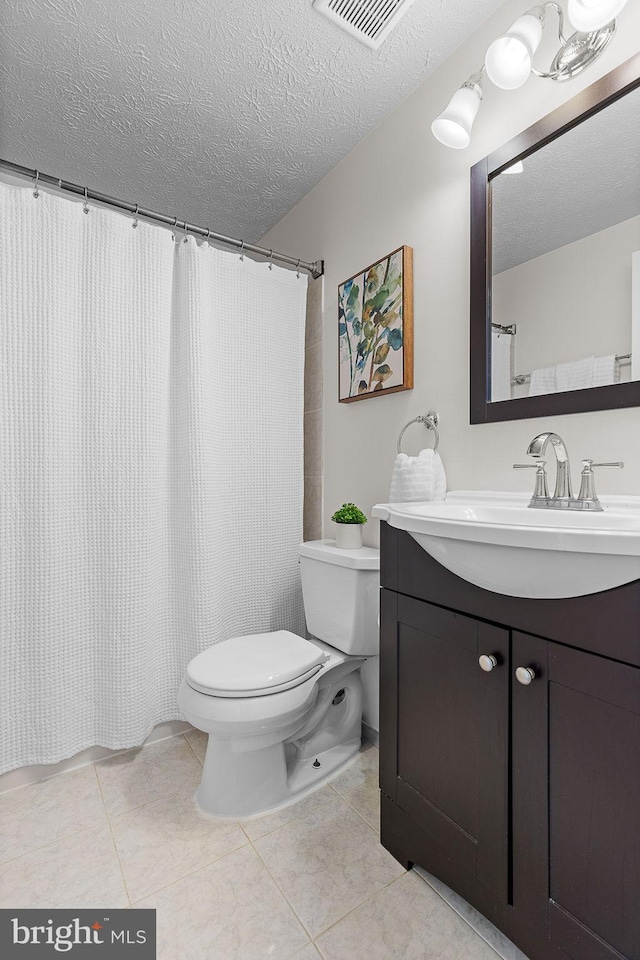 bathroom with tile patterned flooring, toilet, visible vents, and a textured ceiling