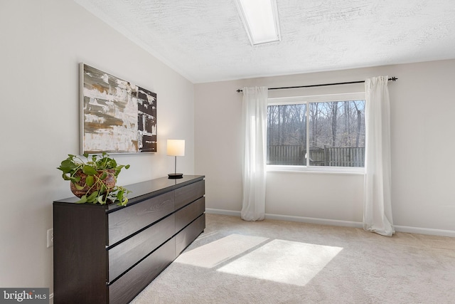 carpeted bedroom featuring baseboards and a textured ceiling