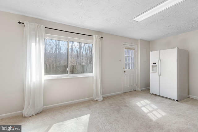 interior space with a textured ceiling and baseboards