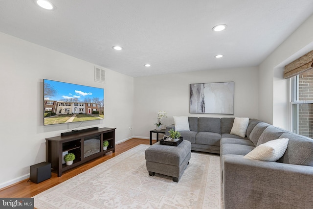 living room featuring recessed lighting, wood finished floors, visible vents, and baseboards