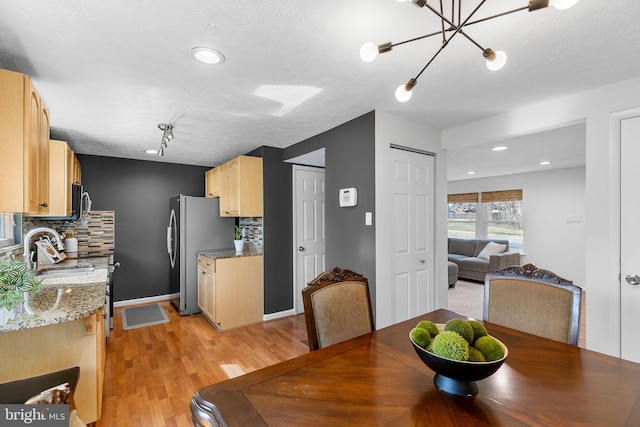 dining space featuring recessed lighting, light wood finished floors, and a textured ceiling