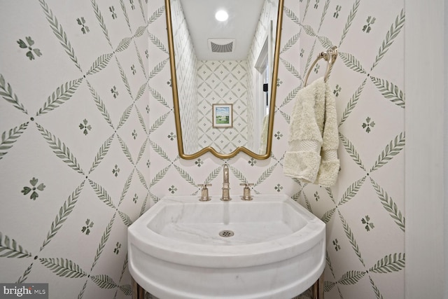 bathroom featuring recessed lighting, a sink, visible vents, and wallpapered walls