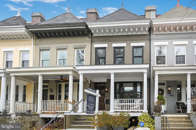 townhome / multi-family property with a porch and brick siding