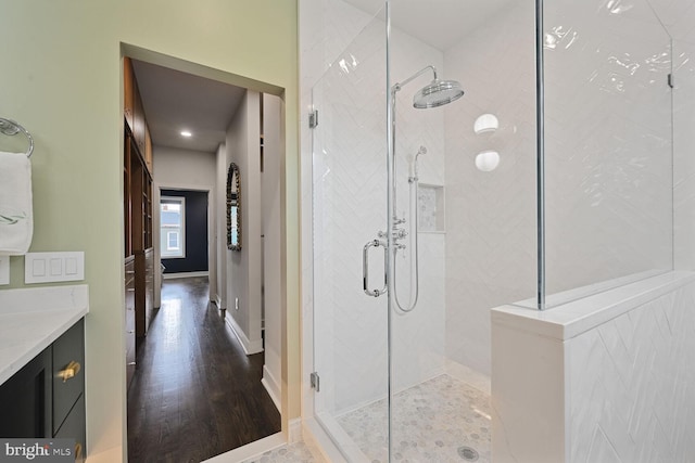 full bathroom featuring a stall shower, vanity, and baseboards