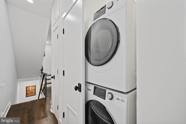 laundry area with laundry area, stacked washing maching and dryer, and wood finished floors