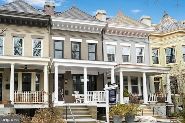 view of property featuring a high end roof, covered porch, and brick siding