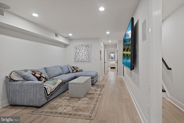 living room featuring light wood-type flooring, baseboards, and recessed lighting