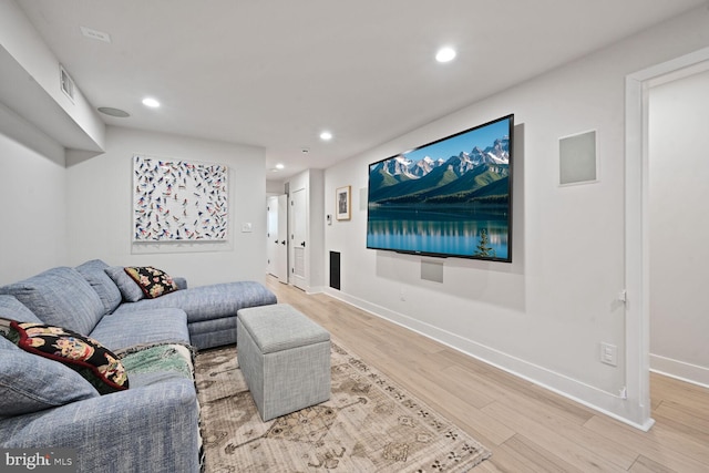 living area featuring recessed lighting, visible vents, baseboards, and wood finished floors